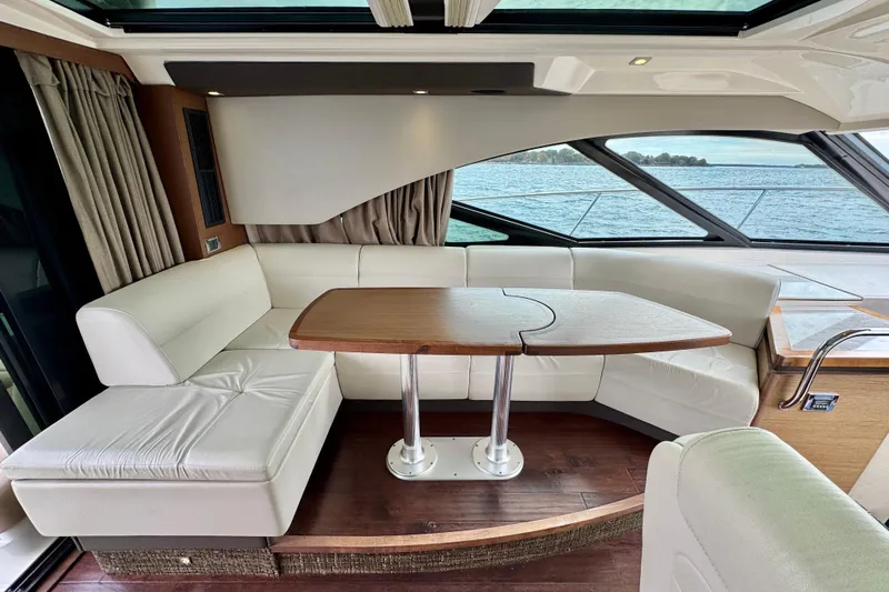 Floor It Yacht Photos Pics Luxurious interior of 2014 Sea Ray 510 Sundancer yacht with elegant seating and wooden table.