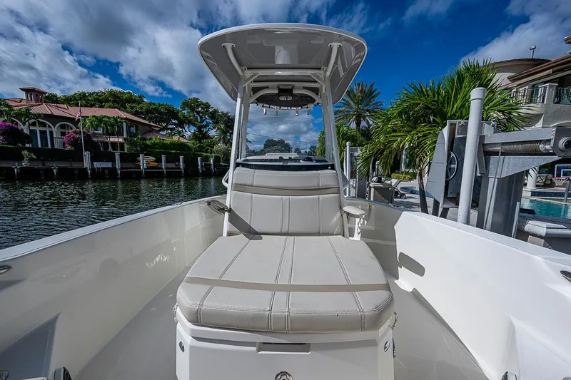  Yacht Photos Pics 2023 Boston Whaler 250 Dauntless boat interior with seating, docked by waterfront homes.