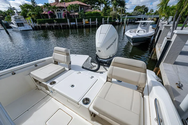  Yacht Photos Pics 2023 Boston Whaler 250 Dauntless boat with Mercury engine docked by waterfront homes.