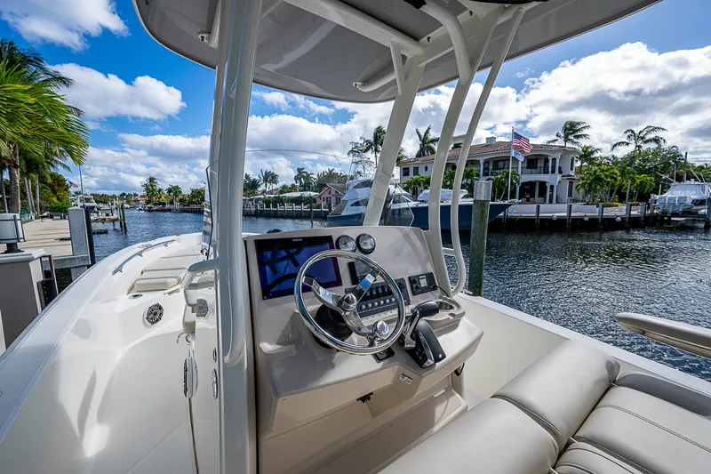  Yacht Photos Pics 2023 Boston Whaler 250 Dauntless boat interior with steering wheel, dockside view.