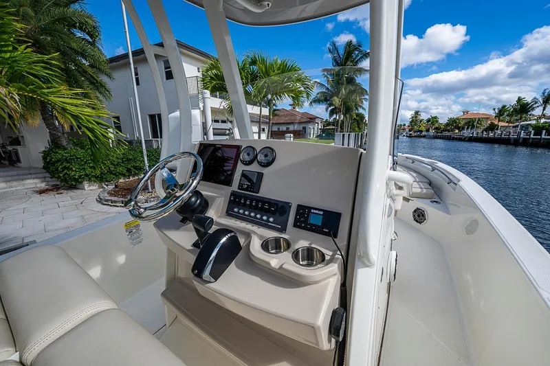  Yacht Photos Pics 2023 Boston Whaler 250 Dauntless boat interior with steering console, near waterfront homes.