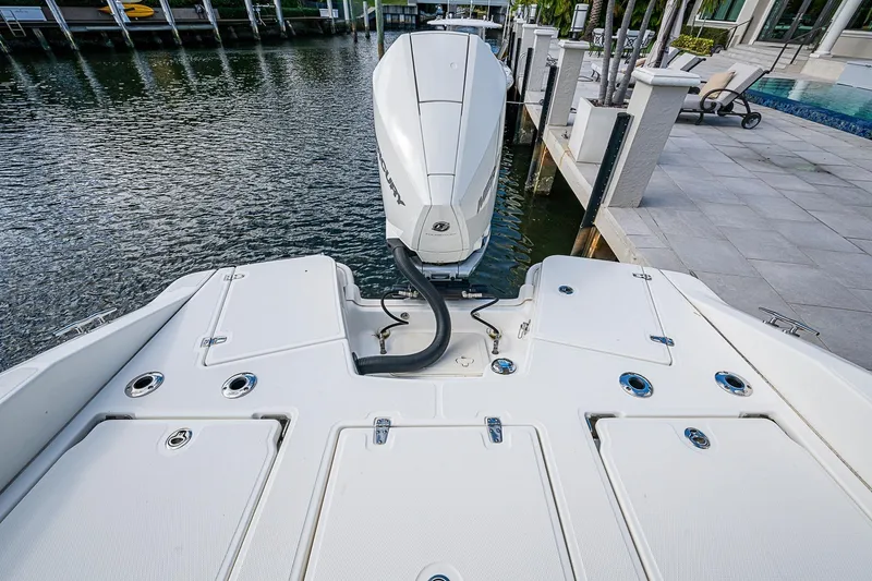  Yacht Photos Pics 2023 Boston Whaler 250 Dauntless boat docked, showcasing rear deck and outboard motor.