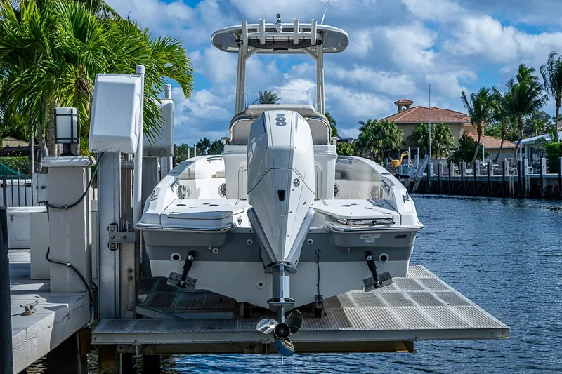  Yacht Photos Pics 2023 Boston Whaler 250 Dauntless boat docked by a scenic waterfront.