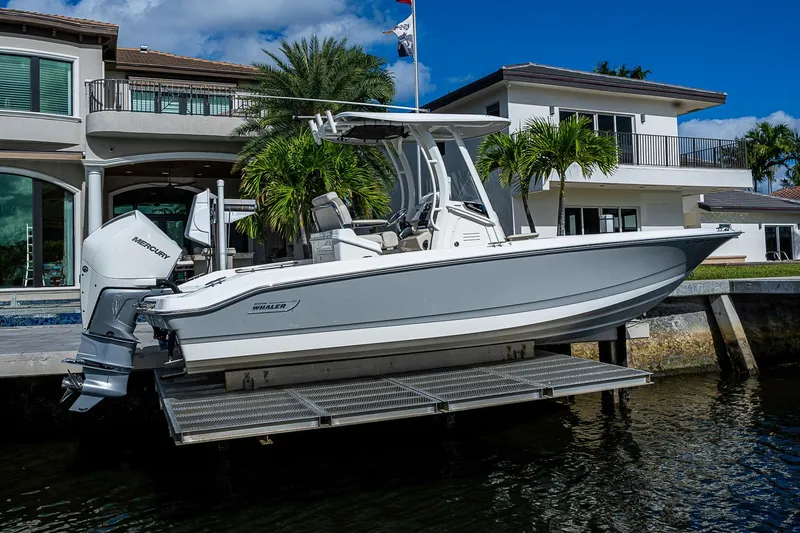  Yacht Photos Pics 2023 Boston Whaler 250 Dauntless boat docked near luxury waterfront home.