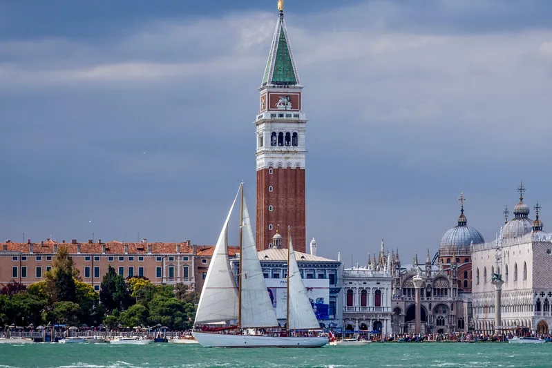 Barinia Yacht Photos Pics Vintage 1950 MOLLICH Sailing boat in Venice with historic architecture backdrop.