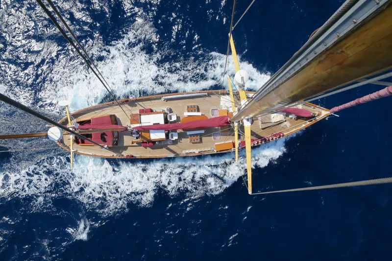 Barinia Yacht Photos Pics Aerial view of 1950 MOLLICH Sailing yacht navigating through deep blue ocean waters.