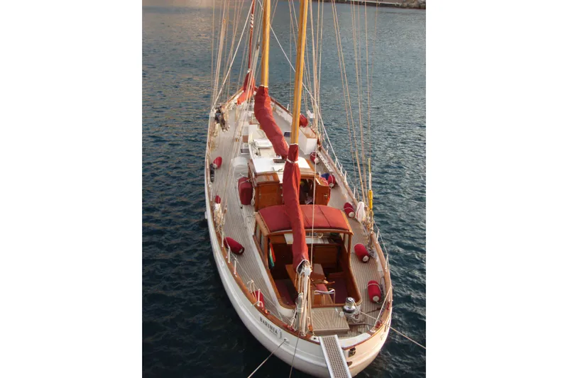 Barinia Yacht Photos Pics 1950 MOLLICH Sailing yacht on calm waters, featuring classic wooden design and red accents.