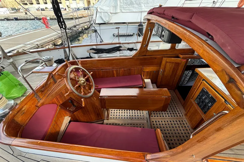 Barinia Yacht Photos Pics Vintage 1950 MOLLICH Sailing boat interior with wooden helm and maroon seating.