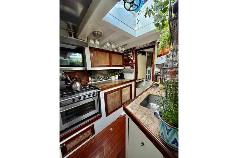 Barinia Yacht Photos Pics 1950 MOLLICH Sailing yacht kitchen with wooden cabinets and modern appliances.