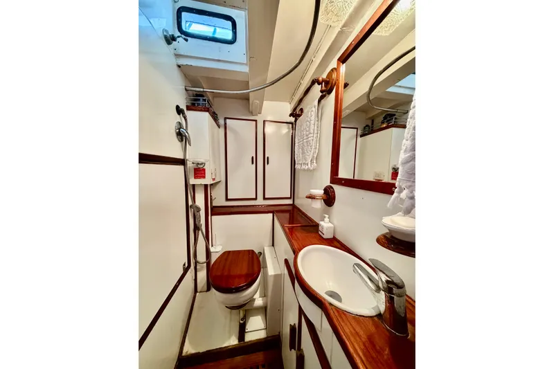 Barinia Yacht Photos Pics Vintage 1950 MOLLICH Sailing yacht bathroom with wooden accents and compact design.