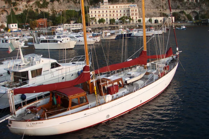 Barinia Yacht Photos Pics Vintage 1950 MOLLICH Sailing yacht docked in a scenic marina.