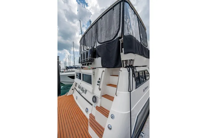 Bada Bing Yacht Photos Pics 1991 Cruisers Yachts 3850 Aft Cabin with covered upper deck, docked under cloudy skies.