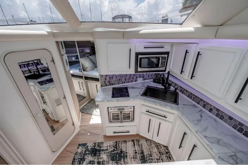 Bada Bing Yacht Photos Pics Luxurious 1991 Cruisers Yachts 3850 Aft Cabin kitchen with modern appliances and marble countertops.