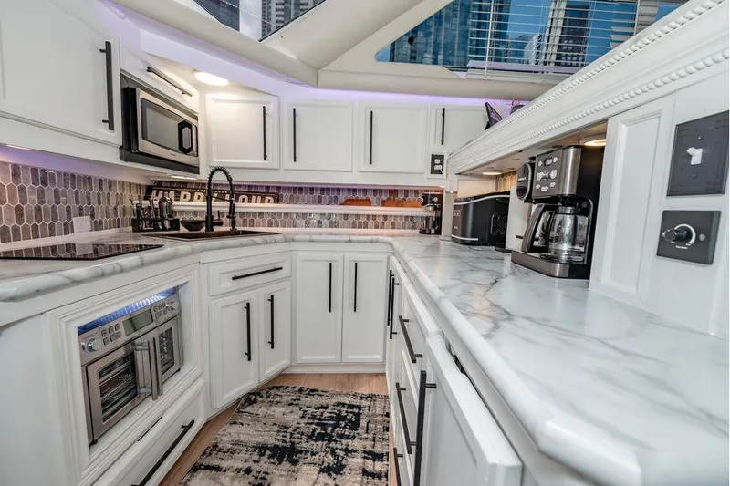 Bada Bing Yacht Photos Pics Luxurious 1991 Cruisers Yachts 3850 Aft Cabin kitchen with modern appliances and marble countertops.