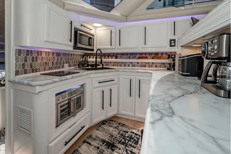 Bada Bing Yacht Photos Pics Luxurious 1991 Cruisers Yachts 3850 Aft Cabin kitchen with modern appliances and marble countertops.