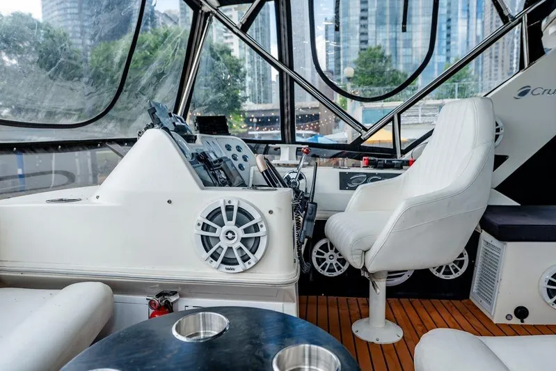 Bada Bing Yacht Photos Pics 1991 Cruisers Yachts 3850 Aft Cabin interior with helm, white seating, and cityscape view.