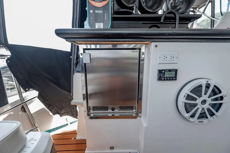 Bada Bing Yacht Photos Pics 1991 Cruisers Yachts 3850 Aft Cabin interior with fridge, speaker, and control panel.
