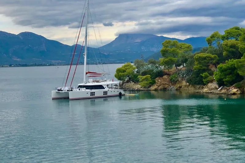 Grace Yacht Photos Pics Catamaran Sunreef 60 LOFT 2013 anchored near lush coastline with mountains in the background.