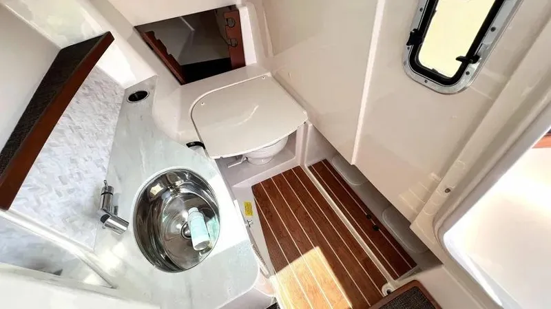  Yacht Photos Pics 2019 Grady-White Freedom 325 boat interior with sink, toilet, and wooden flooring.