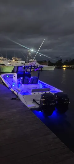 Dealer Demo Yacht Photos Pics 2023 Sea Pro 320 DLX Center Console boat docked at night with blue LED lights.