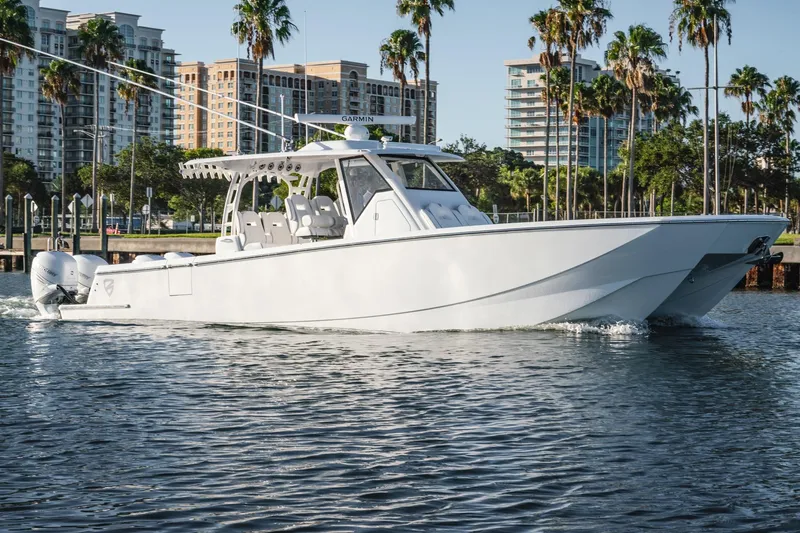  Yacht Photos Pics 2026 Barker Boatworks 40HPC cruising on water with cityscape and palm trees in background.