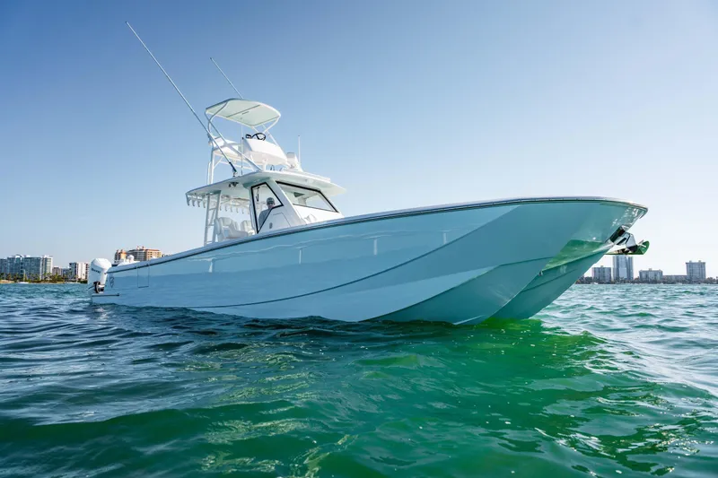  Yacht Photos Pics 2026 Barker Boatworks 40HPC cruising on clear blue water near city skyline.