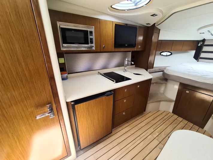 2015 Cruisers Yachts 350 Express Yacht Photos Pics 2015 Cruisers Yachts 350 Express interior with kitchenette, microwave, and bed.