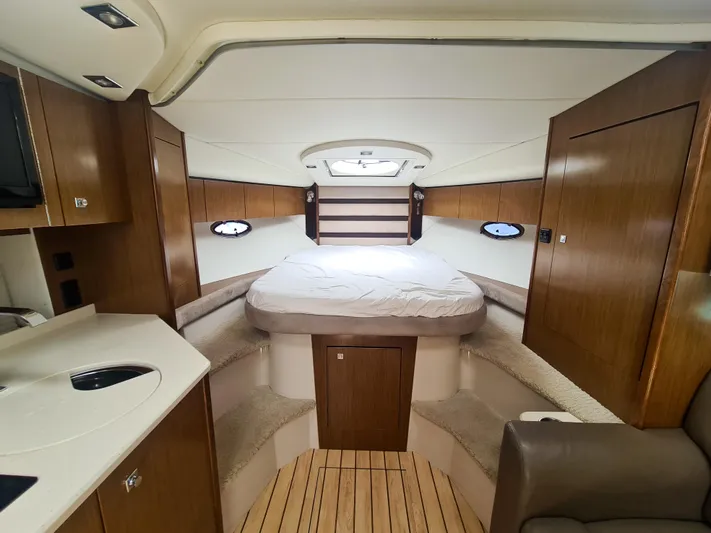 2015 Cruisers Yachts 350 Express Yacht Photos Pics 2015 Cruisers Yachts 350 Express cabin interior with bed, wood finish, and portholes.