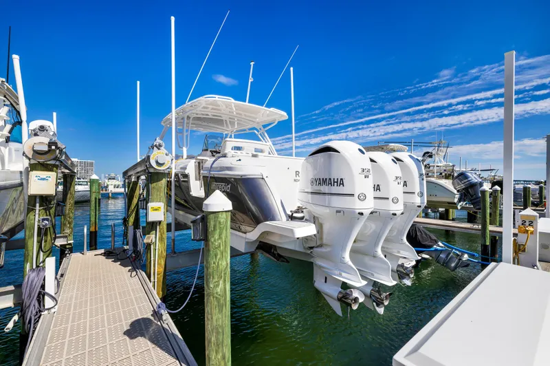  Yacht Photos Pics 2016 Intrepid 400 Cuddy boat with triple Yamaha engines docked at a marina.