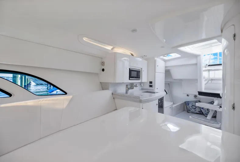  Yacht Photos Pics Interior of 2016 Intrepid 400 Cuddy, featuring modern white design and compact kitchen area.