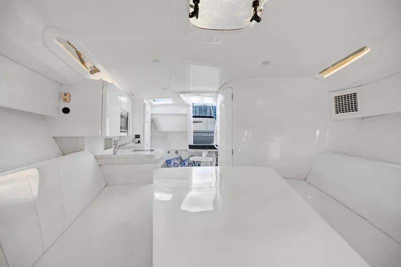  Yacht Photos Pics Interior of 2016 Intrepid 400 Cuddy boat with white seating and kitchenette.