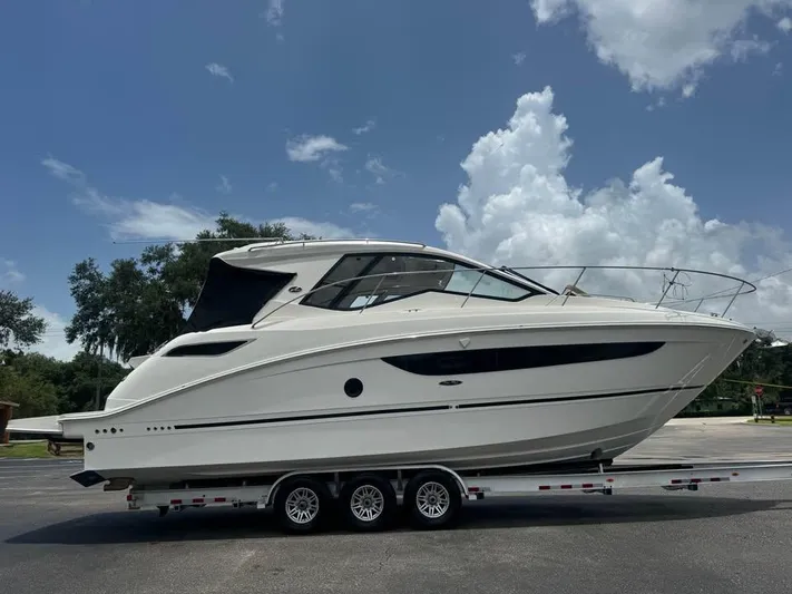  Yacht Photos Pics 2017 Sea Ray Sundancer 350 Coupe on trailer under blue sky.