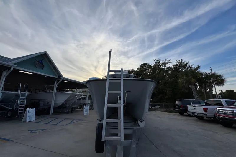  Yacht Photos Pics 2021 Invincible 35' Catamaran on trailer at dealership, under a cloudy sky.