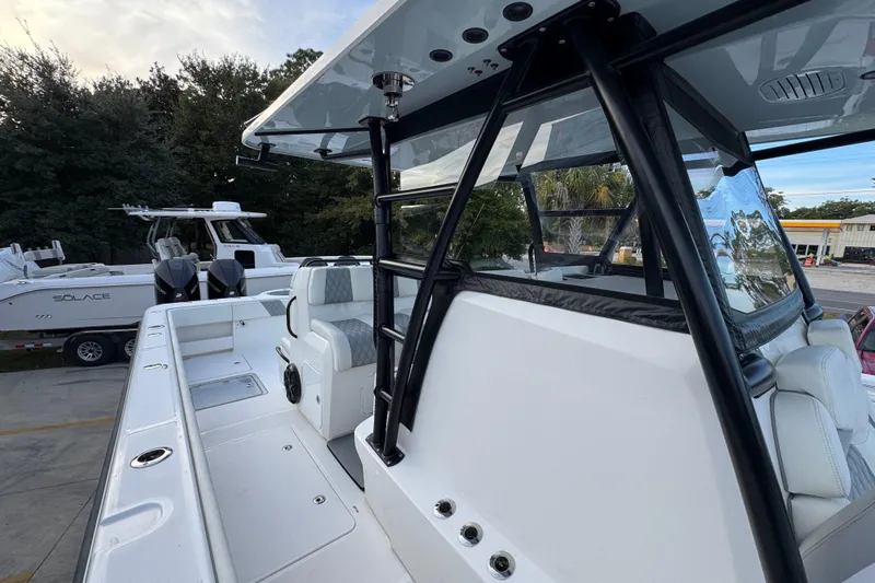  Yacht Photos Pics 2021 Invincible 35' Catamaran with sleek design and spacious seating, docked near other boats.