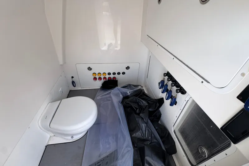  Yacht Photos Pics Interior of 2021 Invincible 35' Catamaran featuring a compact marine toilet and control panel.