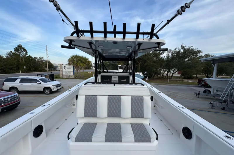  Yacht Photos Pics 2021 Invincible 35' Catamaran with cushioned seating and fishing rod holders, parked outdoors.