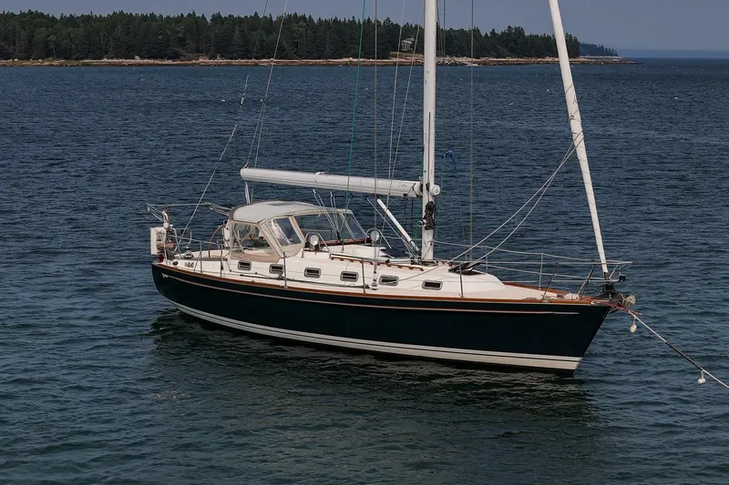 Jericho Yacht Photos Pics 2002 Tartan 4100 sailboat on calm water with forested shoreline in background.