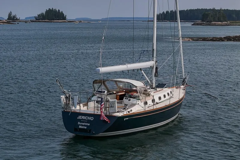 Jericho Yacht Photos Pics Sailboat Tartan 4100 (2002) named Jericho on calm waters near forested islands.