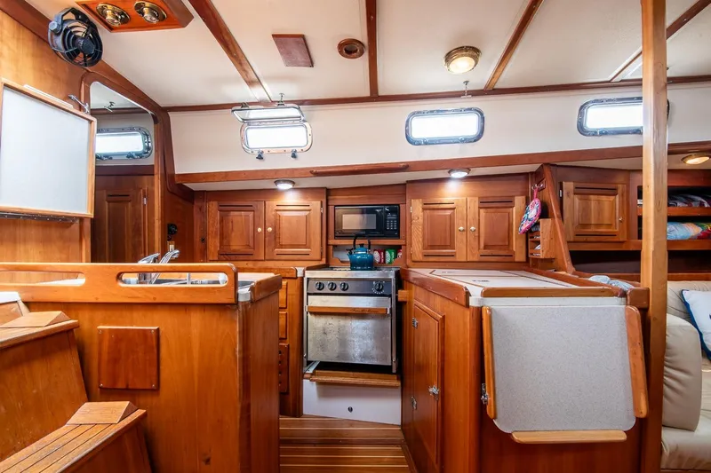Jericho Yacht Photos Pics Cozy Tartan 4100 yacht interior kitchen with wooden cabinetry, stove, and microwave, 2002 model.