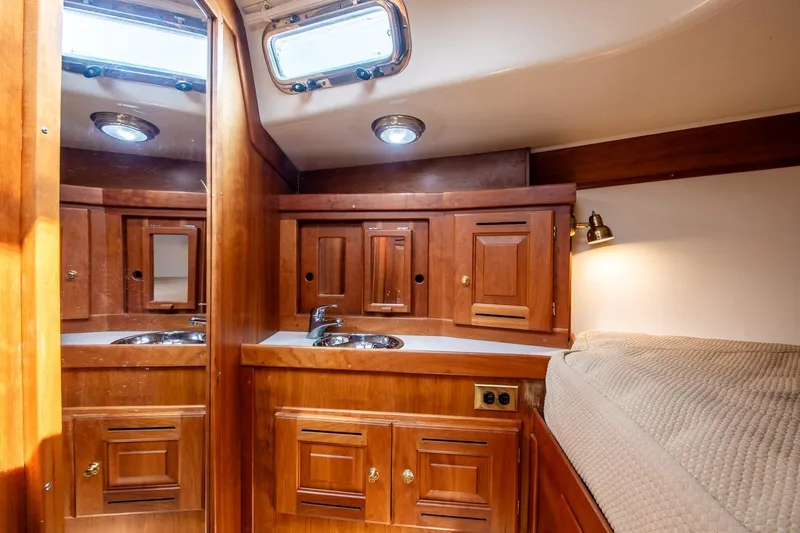 Jericho Yacht Photos Pics Luxurious 2002 Tartan 4100 yacht interior with wooden cabinetry and cozy sleeping area.
