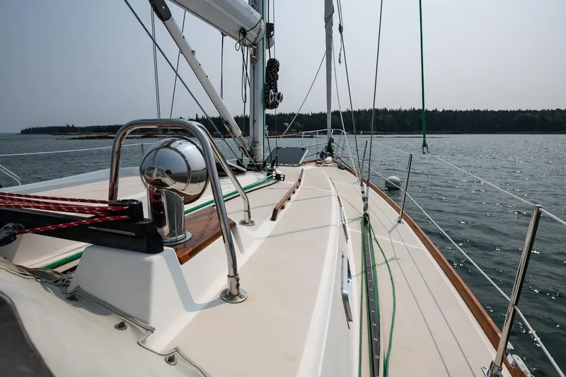 Jericho Yacht Photos Pics Sailing on a 2002 Tartan 4100 yacht, calm waters, clear sky, forested shoreline.