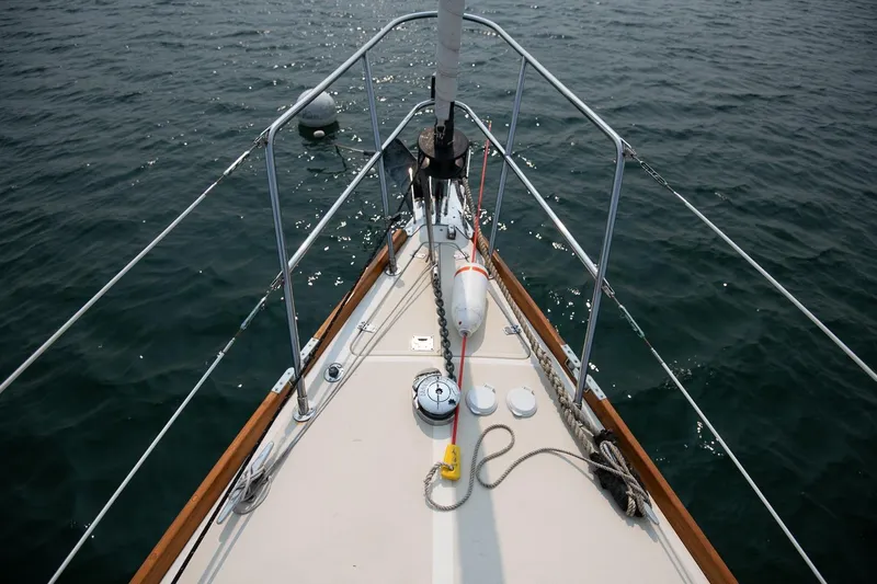 Jericho Yacht Photos Pics Bow of 2002 Tartan 4100 sailboat on calm water, featuring deck and railing.