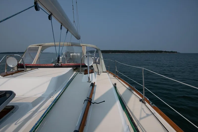 Jericho Yacht Photos Pics Sailing on a 2002 Tartan 4100 yacht, calm waters, clear sky, distant shoreline.