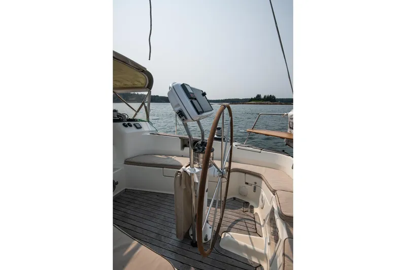 Jericho Yacht Photos Pics 2002 Tartan 4100 sailboat cockpit with wooden wheel, overlooking serene waters.