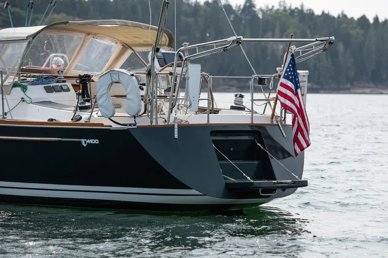 Jericho Yacht Photos Pics Sailboat Tartan 4100 (2002) with American flag on calm water.