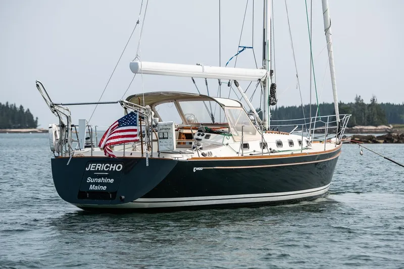 Jericho Yacht Photos Pics Sailboat Tartan 4100, 2002 model, named Jericho, anchored in calm waters with American flag.