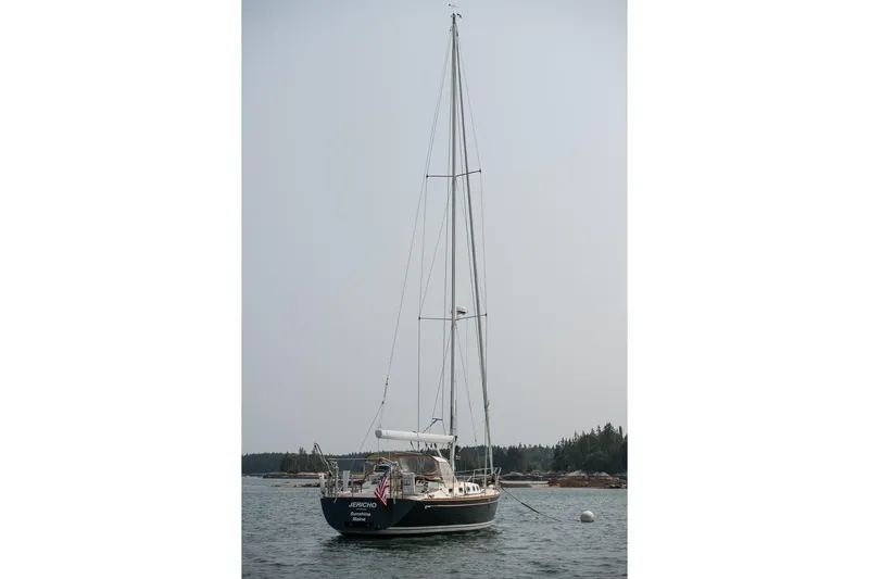 Jericho Yacht Photos Pics Sailboat Tartan 4100, 2002 model, anchored in calm waters with forested shoreline.