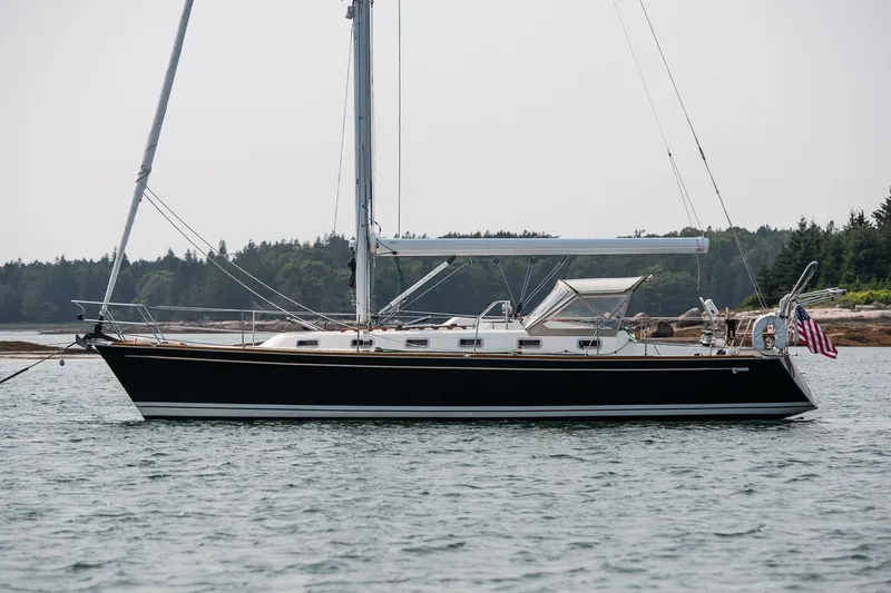 Jericho Yacht Photos Pics 2002 Tartan 4100 sailboat anchored on calm water with forested shoreline.