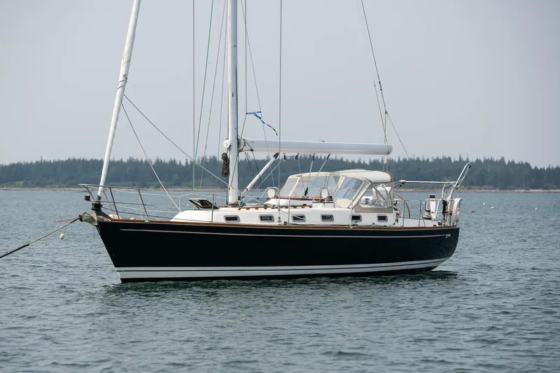 Jericho Yacht Photos Pics Sailboat Tartan 4100, 2002 model, anchored on calm water with forested shoreline.