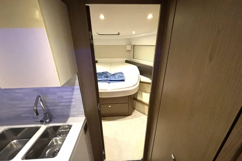  Yacht Photos Pics Interior of 2015 Beneteau Gran Turismo 49 yacht, featuring a cozy bedroom and kitchenette.